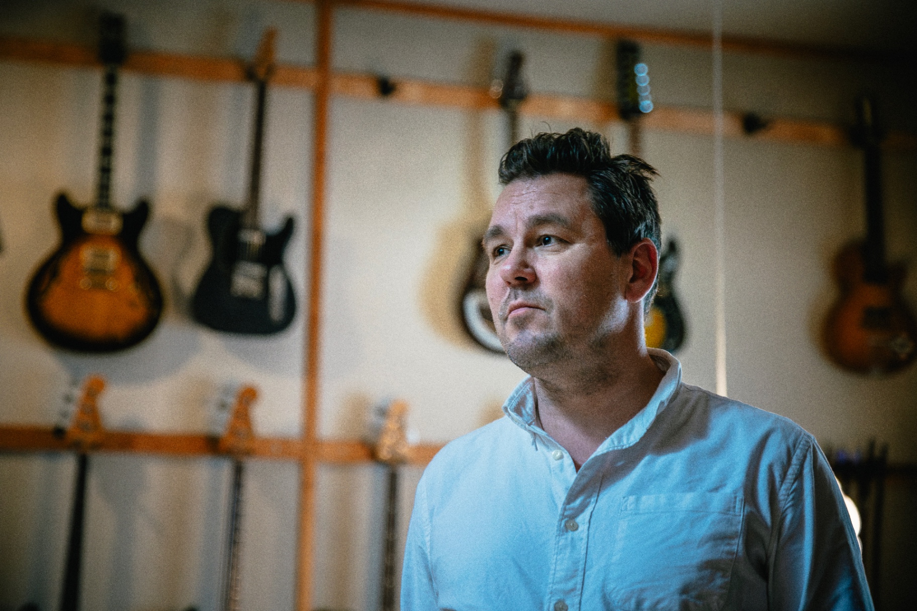 Nicolai Majland in the studio with guitars in the background